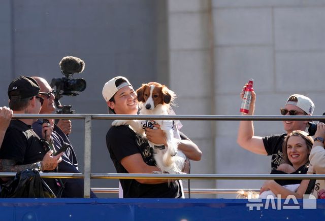 [로스앤젤레스=AP/뉴시스] LA 다저스의 오타니 쇼헤이가 1일(현지시각) 미 캘리포니아주 로스앤젤레스에서 열린 2024 월드시리즈(WS) 우승 기념 퍼레이드에서 반려견 디코이(일본명 데코핀)를 안고 있다. 다저스는 WS에서 뉴욕 양키스에 4승1패를 거두고 통산 8번째 정상에 올랐다 2024.11.02. / 사진 = 뉴시스