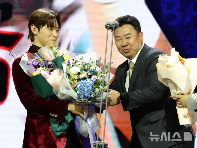 KIA 타이거즈 김도영이 13일 오후 서울 강남구 코엑스 오디토리움에서 열린 2024 KBO 골든글러브 시상식에서 3루수 부문 골든글러브를 수상한 후 이범호 감독에게 꽃다발을 받고 있다. 2024.12.13. / 사진 = 뉴시스