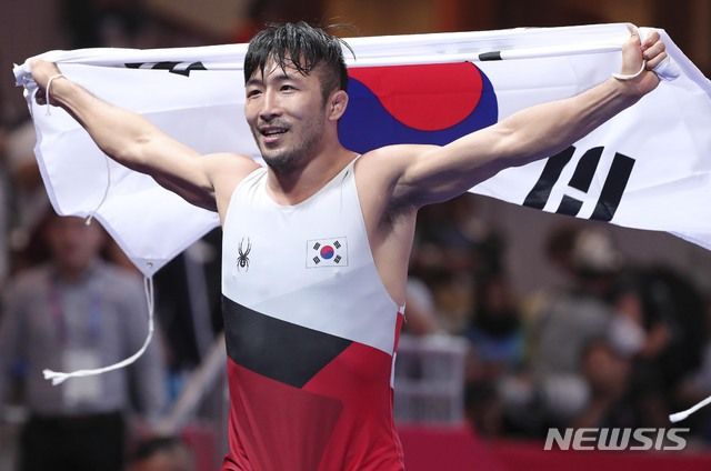 21일(현지시각) 오후 인도네시아 자카르타 컨벤션센터에서 열린 '2018 자카르타-팔렘방 아시아안게임' 레슬링 남자 그레코로만형 67kg급 금메달 결정전에서 한국 류한수가 금메달을 차지한 뒤 태극기를 들고 기뻐하고 있다. 2018.08.21. / 사진 = 뉴시스