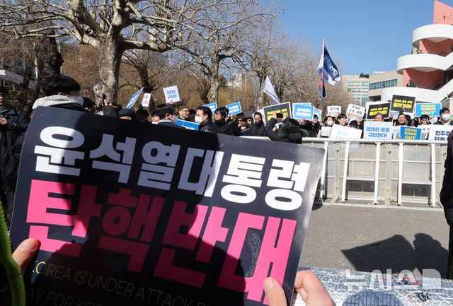 윤석열 대통령 탄핵 찬성 집회가 열리는 가운데, 탄핵반대 측 지지자가 피켓을 들고 있다. 2025.02.26. / 사진 = 뉴시스