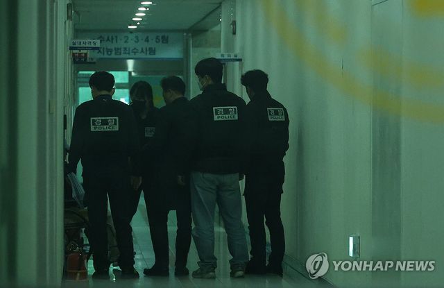 7일 오후 대전서부경찰서에서 첫 대면조사를 마친 대전 초등생 살해 교사 명모(40대) 씨가 조사실을 나오고 있다. 경찰들이 명씨를 유치장에 입감하기 위해 이동시키고 있다. 2025.3.7 / 사진 =연합뉴스