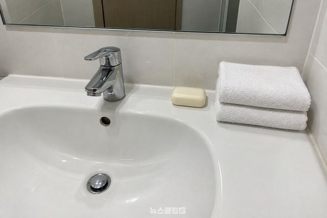 마른 고체 비누와 깨끗한 수건 두 장을 거울 앞 세면대에 준비한 모습. / 기사 이해를 돕기 위한 생성형 이미지