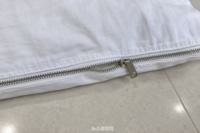열린 베개커버 지퍼의 끝부분에서 이빨과 슬라이더가 보이는 가까운 모습. / 기사 이해를 돕기 위한 생성형 이미지