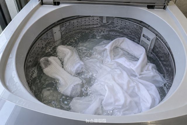 세제 물에 잠긴 빨래가 통돌이 세탁조 안에서 천천히 움직이는 모습. / 기사 이해를 돕기 위한 생성형 이미지