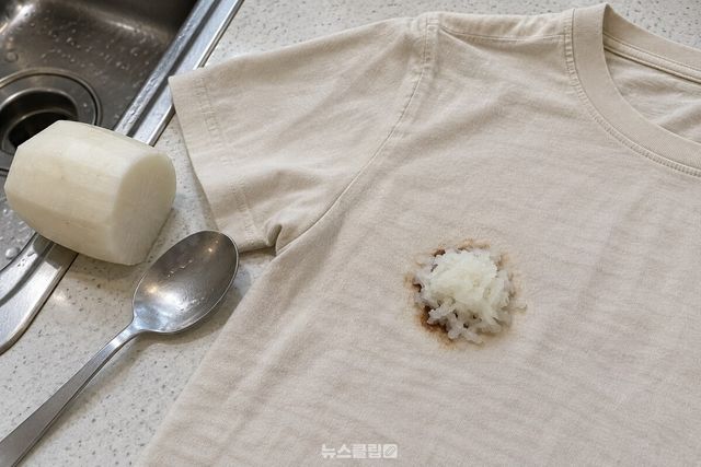 밝은색 티셔츠의 짜장 자국 위에 간 무를 올린 모습 / 기사 이해를 돕기 위한 생성형 이미지