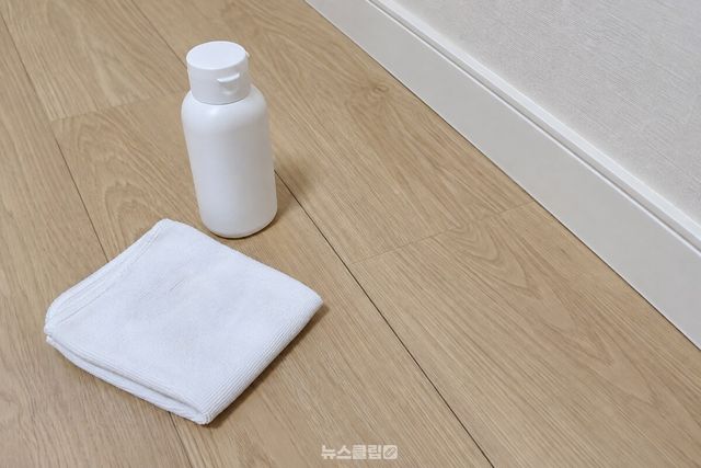 거실 마루 이음새 가까이에 베이비파우더 통과 마른 면 천을 놓은 모습. / 기사 이해를 돕기 위한 생성형 이미지