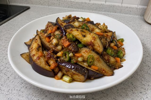 흰 반찬 접시에 담은 매콤한 구운 가지무침 / 기사 이해를 돕기 위한 생성형 이미지