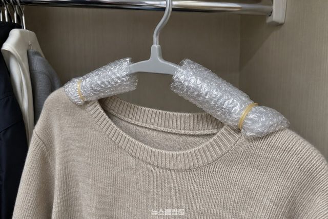 뽁뽁이를 감아 고무줄로 고정한 옷걸이에 니트를 걸어 둔 모습. / 기사 이해를 돕기 위한 생성형 이미지