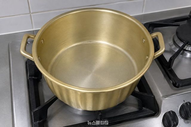 가스레인지 위에 올려진 노란 양은 냄비의 비어 있는 안쪽 면. / 기사 이해를 돕기 위한 생성형 이미지