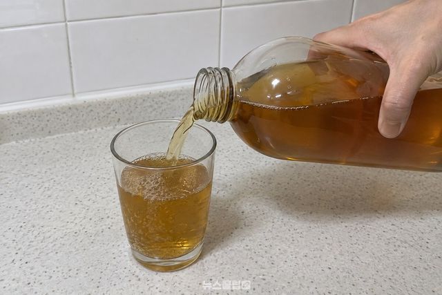 냉장 보관한 보리차를 병에 입대지 않고 컵에 따르는 모습. / 기사 이해를 돕기 위한 생성형 이미지