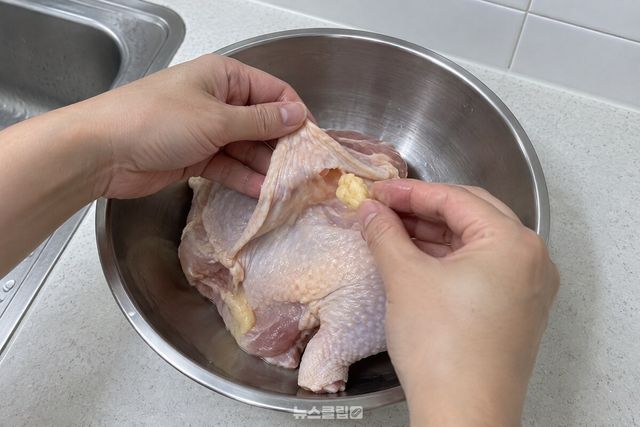 생닭 껍질 안쪽의 노란 지방을 손으로 떼어 내는 가까운 조리 장면. / 기사 이해를 돕기 위한 생성형 이미지