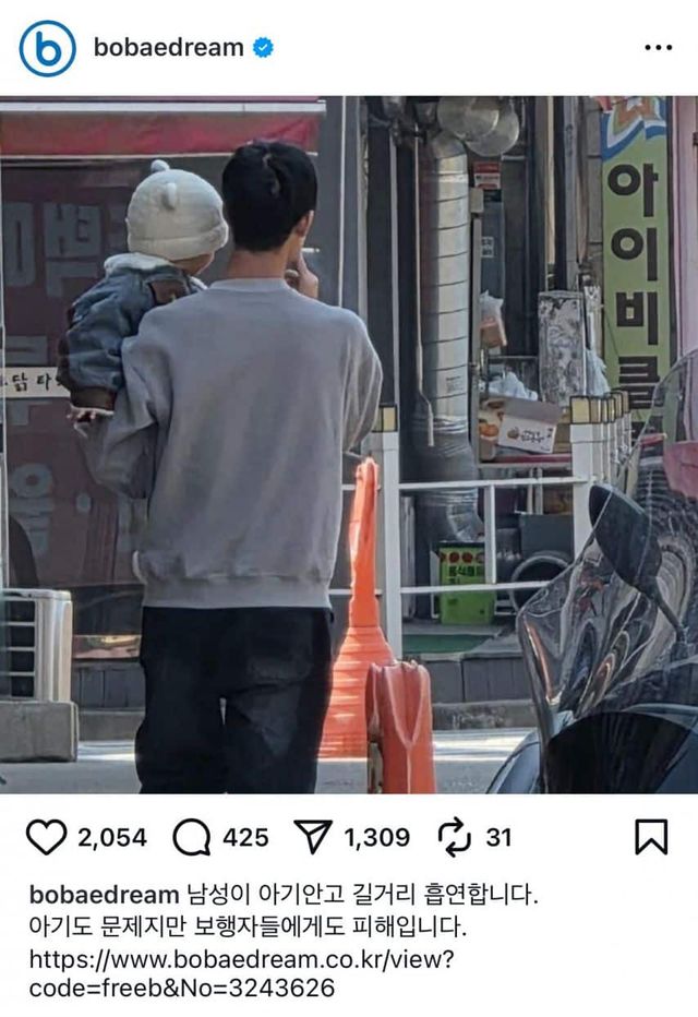 아이를 안고 길빵하는 남자