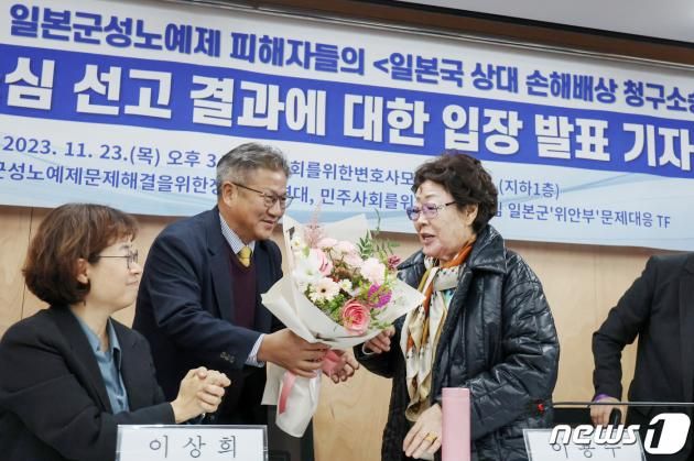 일본군 위안부 피해자 이용수 할머니가 23일 오후 서울 서초구 민주사회를 위한 변호사모임(민변) 사무실에서 열린 '항소심 선고 결과에 대한 입장 발표 기자회견'에서 조영선 민변 회장으로부터 꽃다발을 받고 있다. 이용수 할머니를 비롯한 피해자들은 이날 열린 2차 손해배상 청구 소송 항소심 선고 공판에서 1심 결과를 뒤집고 승소했다. 2023.11.23/뉴스1 ⓒ News1 민경석 기자