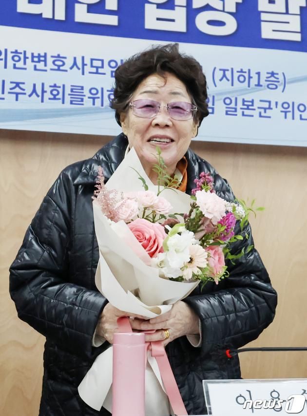 일본군 위안부 피해자 이용수 할머니가 23일 오후 서울 서초구 민주사회를 위한 변호사모임(민변) 사무실에서 열린 '항소심 선고 결과에 대한 입장 발표 기자회견'에서 조영선 민변 회장으로부터 꽃다발을 받은 뒤 기뻐하고 있다. 이용수 할머니를 비롯한 피해자들은 이날 열린 2차 손해배상 청구 소송 항소심 선고 공판에서 1심 결과를 뒤집고 승소했다. 2023.11.23/뉴스1 ⓒ News1 민경석 기자