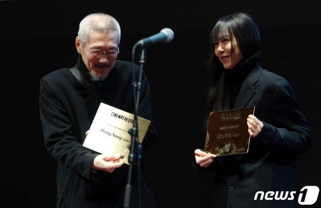 13일 오후(현지시간) 프랑스 파리 시네마테크 프랑세즈에서 열린 ‘홍상수 감독 전작 회고전’에서 개막작 ‘소설가의 영화’ 상영 전 홍상수(64) 감독과 배우 김민희(41)가 무대에 올라 인사를 하던 중 시네마테크 프랑세즈 측으로부터 각각의 이름이 새겨진 황금명패를 선물받고 있다. 2023.02.14/뉴스1 ⓒ News1 이준성 기자