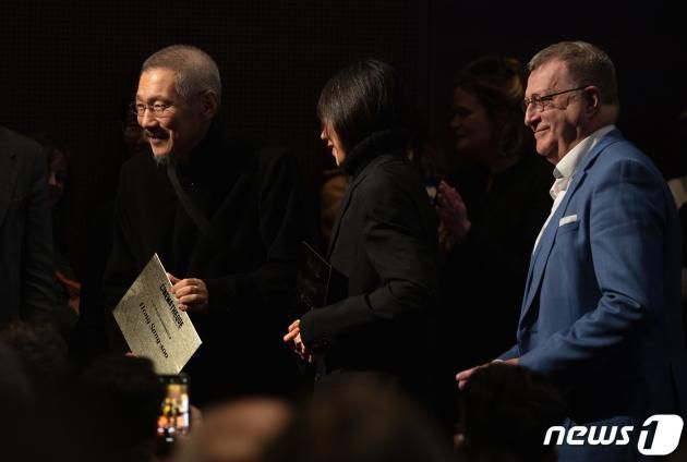 13일 오후(현지시간) 프랑스 파리 시네마테크 프랑세즈에서 열린 ‘홍상수 감독 전작 회고전’에서 개막작 ‘소설가의 영화’ 상영 전 홍상수(64) 감독과 배우 김민희(41)가 무대에 올라 인사를 하던 중 시네마테크 프랑세즈 측으로부터 각각의 이름이 새겨진 황금명패를 선물받고 있다. 2023.02.14/뉴스1 ⓒ News1 이준성 기자