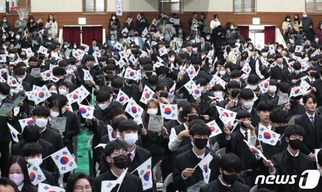 제104주년 3·1절인 1일 오후 경기 수원시 팔달구 삼일공업고등학교 입학식 및 3·1절 기념식에서 신입생들이 삼일절 노래를 부르며 태극기를 흔들고 있다. 2023.3.1/DBC뉴스