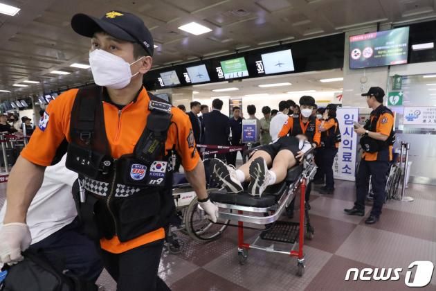26일 오전 제주공항을 출발해 대구공항으로 향하던 아시아나 항공기에서 비행 중 문이 열리는 사고가 발생했다. 울산에서 열리는 제52회 전국소년체육대회에 참가하기 위해 비행기에 탑승했던 초·중학생 제주특별자치도 선수단 가운데 대구공항 도착 직후 고통을 호소하는 선수들을 119구조대가 들것을 이용해 구급차로 옮기고 있다. 2023.5.26/DBC뉴스