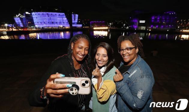 12일 오후 방탄소년단(BTS) 데뷔 10주년을 맞이해 ARMY 상징색인 보랏빛 조명을 밝히고 있는 서울 한강 세빛섬에서 BTS팬인 아미들이 기념사진을 찍고 있다. 2023.6.12/뉴스1 ⓒ News1 박세연 기자