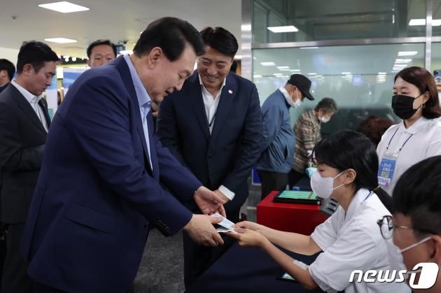 윤석열 대통령이 31일 서울 영등포구 노량진수산시장을 방문, 온누리상품권 환급행사에 대한 설명을 들은 후 구매 영수증을 내고 온누리상품권(2만원)을 환급받고 있다. (대통령실 제공) 2023.8.31/뉴스1 ⓒ News1 오대일 기자