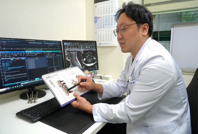 사진1_척추센터박종혁과장이환자에게 설명하고있다