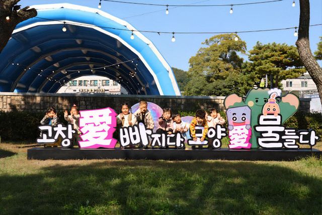 어린아이들이 주제 조형물에서 사진을 찍고 있다