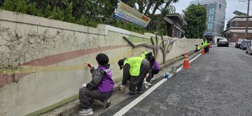 사진 1. 노후된 벽화에 밑그림을 그리고 있는 모습