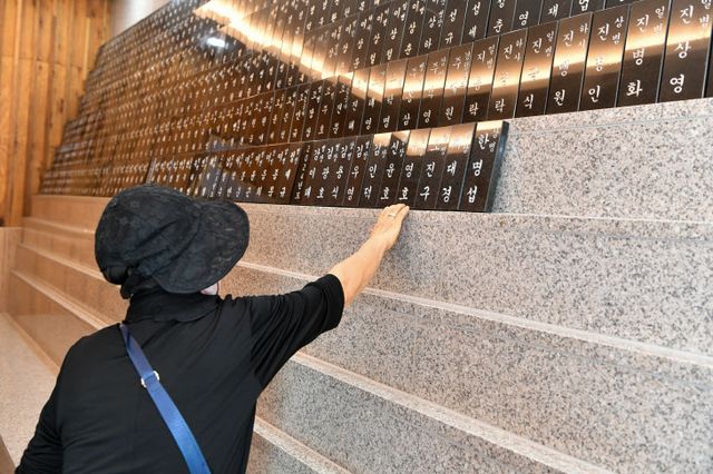 유가족이 위패를 어루만지며 넋을 기리고 있다