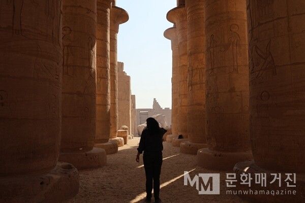 ▲ 이집트 룩소르 카르낙 신전에서 촬영한 카르낙 신전의 거대한 석주 숲 사이로 스며드는 이른 아침 햇살. 이 빛은 신전에서 신의 임재를 상징했으며, 오늘날까지 사암 기둥에 새겨진 부조를 부드럽게 비춘다 / 사진: 한민광 제공
