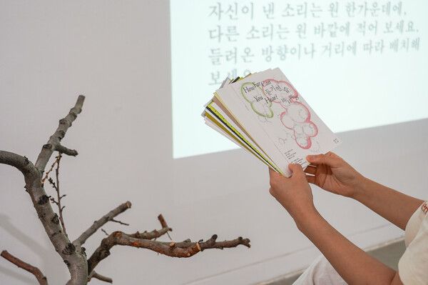 ▲ 연주와 질문에 따라 다양한 색과 질감의 종이를 고르는 관객의 모습 / 사진: 블루메미술관 제공&nbsp;