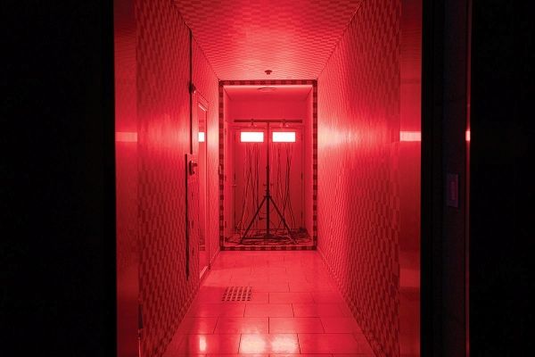 ▲ 무한한 디지털 공허를 상징하는 회색 체커보드 무늬의 UV 그리드와 붉은 조명으로 채워진 복도 공간 / 사진: 남서원, 제공: 아트선재센터