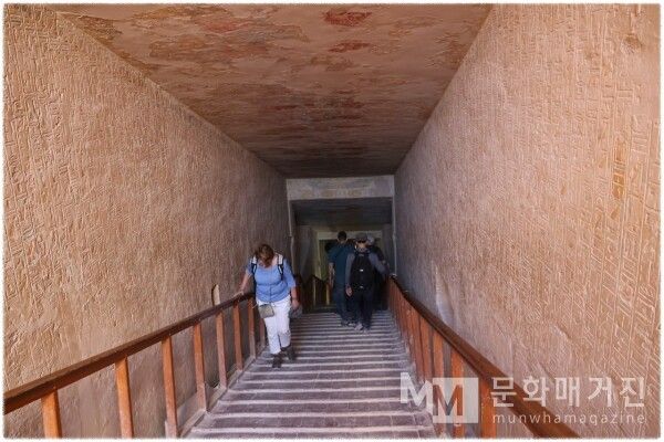 ▲ 관람객들이 계단을 내려가는 직선형 회랑의 내부. 양쪽 벽면에는 성각문자가 빽빽하게 음각되어 있고 천장에는 붉은색 안료의 흔적이 남아 있다 / 사진: 한민광 제공
