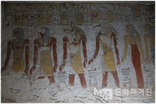 ▲ 백색 석고 벽면 위에 나란히 서 있는 신들의 채색 벽화로, 아누비스와 이비스 머리의 토트 신, 그리고 주황색 드레스를 입은 여신들이 차례로 배치되어 있다 / 사진: 한민광 제공