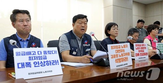 류기섭 한국노총 사무총장 등 최저임금위 근로자위원들이 22일 오후 정부세종청사 고용노동부에서 내년도 적용 최저임금 최초안을 발표고 있다. 근로자위원은 내년도 최저임금으로 1만2210원을 요구하는 한편 김준영 근로자위원의 강제 해촉과 관련해 유감을 표했다.