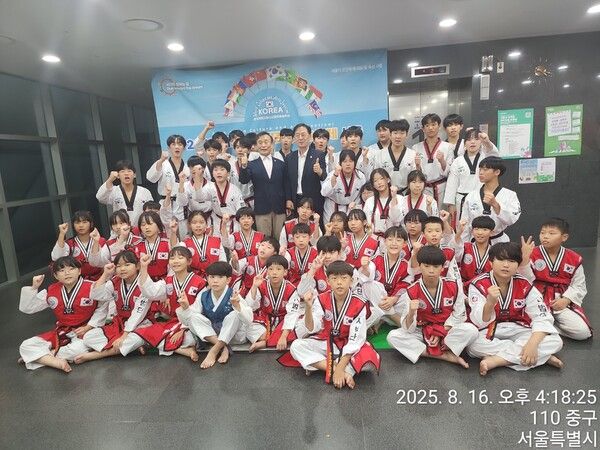 8월 16일 서울시청 8층 다목적홀에서 거행된'2025 세계어린이청소년문화예술축제 in Seoul'에 참가한 세계어린이태권도연맹 시범단장(지현철 강동구태권도협회장)과 세계어린이태권도연맹 이상기 총재와 행사에 참가한 어린이태권도 시범단 단원들이 행사 포토존 앞에서 합동 기념촬영/사진=세계어린이태권도연맹(WCTU)제공