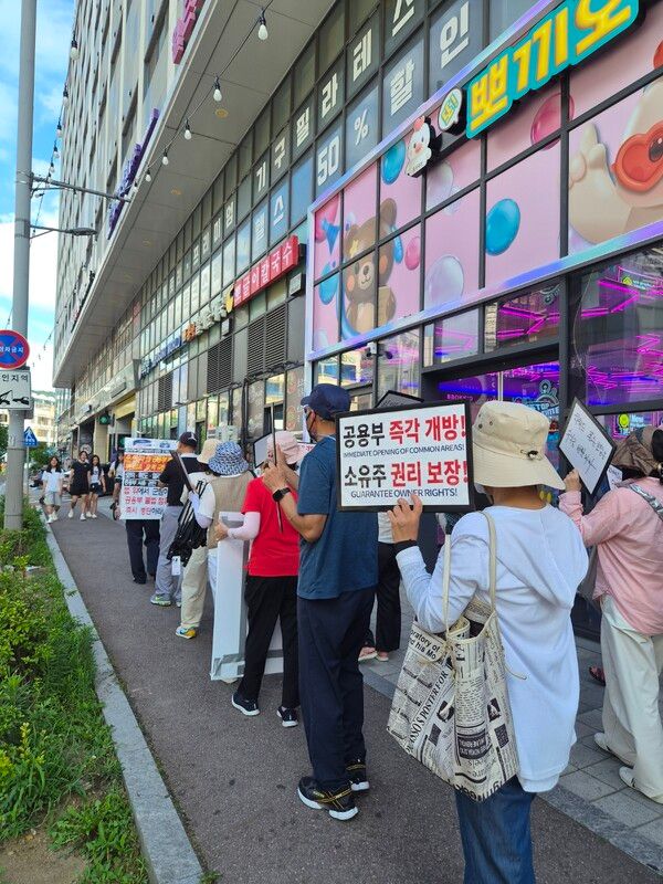 호텔앞에서 성난 수분양자들이&nbsp; 피켓을 들고 시위하는&nbsp; 모습