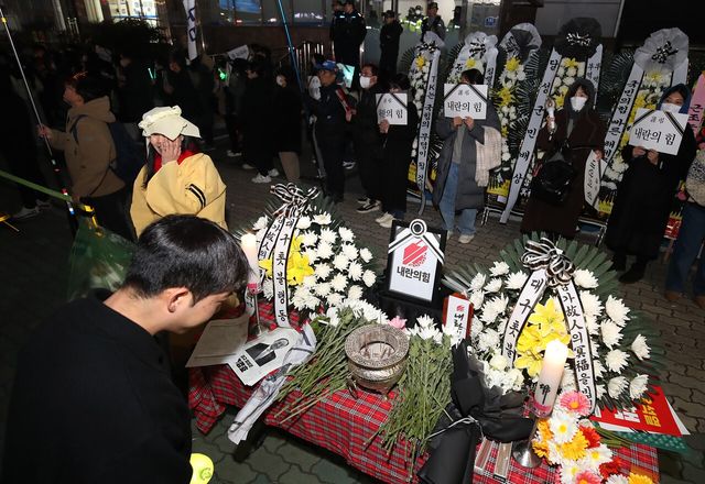 ▲ 11일 대구 수성구 범어동 국민의힘 대구경북 당사 앞에서 열린 '내란공범 국짐당 장례식' 분향소에서 분향과 헌화 중인 시민들(사진= 뉴스1)