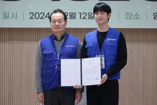 ▲이용욱 복권위원회 사무처장이 12일 서울 마포구 염리종합사회복지관에서 열린 '17기 행복공감봉사단' 봉사활동에서 배우 정해인에게 감사장을 수여한뒤 기념촬영을 하고 있다. (사진=연합뉴스)