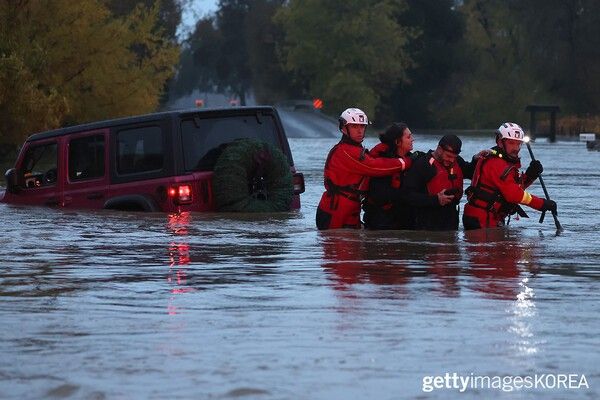 ▲24년 11월 22일 캘리포니아 윈저에서 홍수로 인해 차가 침수된 후 부부를 구조하는 소방관 (사진= gettyimagesKOREA)