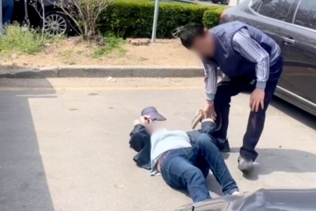 한 여성이 주차공간에 누워 다른 이들의 주차를 방해하는 모습 /사진=온라인 커뮤니티