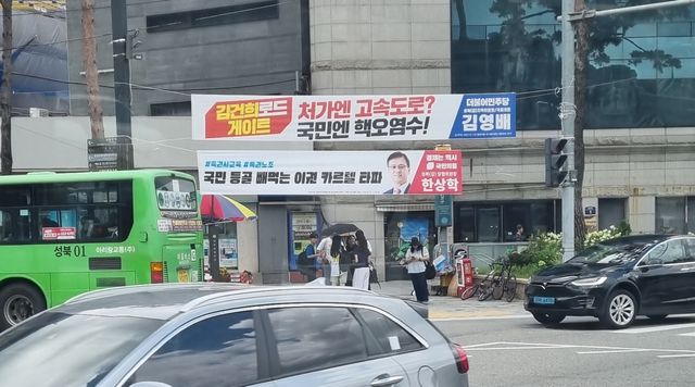 서울 지하철 4호선 한성대입구역 앞에 국민의힘과 더불어민주당 정당 현수막이 각각 걸려있다. /이현주