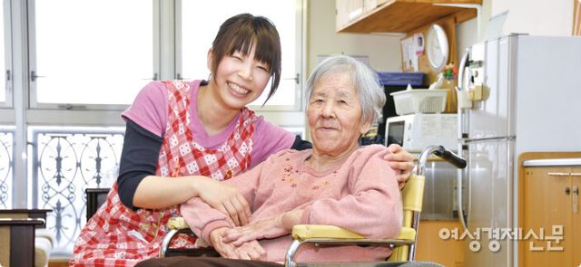 일본 교토에 위치한 한 요양원에 근무중인 요양보호사 와타나베 코헤이(54)씨가 입소 노인과 환한 미소를 짓고 있다. /여성경제신문