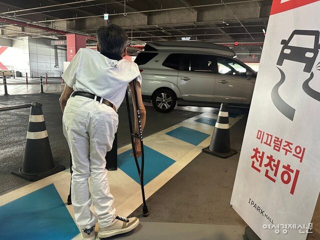 이성수 씨가 용산 아이파크몰 주차장의 보행 안전 통로를 통해 걸어가던 중 지나가는 차량에 멈춰 섰다. 차량 경로와 보행 안전 통로가 겹침을 알 수 있다. /여성경제신문