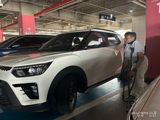 평소 목발을 사용하는 운전자 이성수 씨(남‧62세)가 용산 아이파크몰 장애인 전용 주차구역에 주차 후 차에서 내리고 있다. /여성경제신문