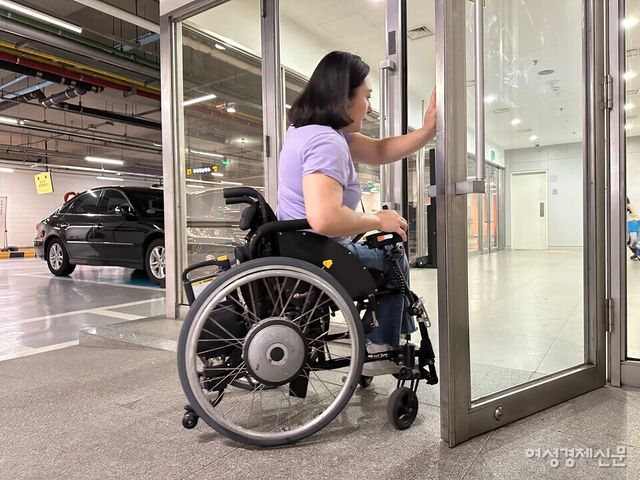 홍서윤 씨(여·38)가 SK텔레콤 본사 지하 주차장과 연결된 출입구 문을 한 손으로 열고 있다. /여성경제신문