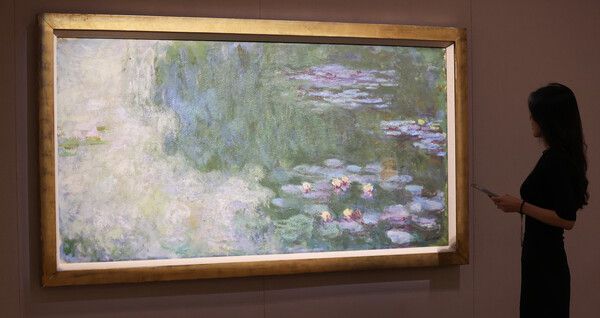 30일 경기 국립현대미술관 과천에서 열린 MMCA 해외 명작 '수련과 샹들리에' 언론공개회에 참석자가 클로드 모네의 '수련이 있는 연못'을 둘러보고 있다. /연합뉴스