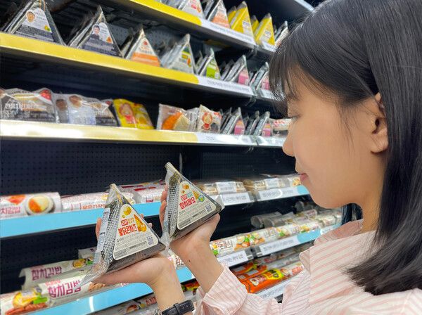 GS25가 역대 최고 스펙으로 삼각김밥 '풀체인지 리뉴얼'을 추진하고 있다. 모델이 GS25가 '풀체인지 리뉴얼'을 완료한 '더큰 삼각김밥' 시리즈를 살펴보고 있다 /GS25