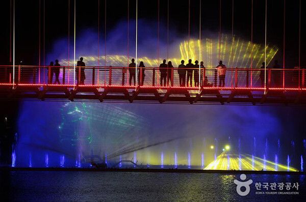 예산여행, 어둠이 내린 예당호출렁다리에서 음악분수를 즐기는 사람들 (사진출처=한국관광공사)