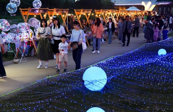 대전시민들이 24일 저녁 목척교 수변공원에서 열린 2024년 동구 문화유산 야행 ‘밤하늘, 달콤한 문화산책’을 즐기고 있다. (사진=동구 제공)