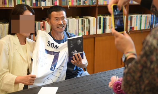 '나는 읽고 쓰고 버린다' 책 저서 손웅정 감독이 팬에게 사인한뒤 기념촬영을 하고 있다. 전우용 기자